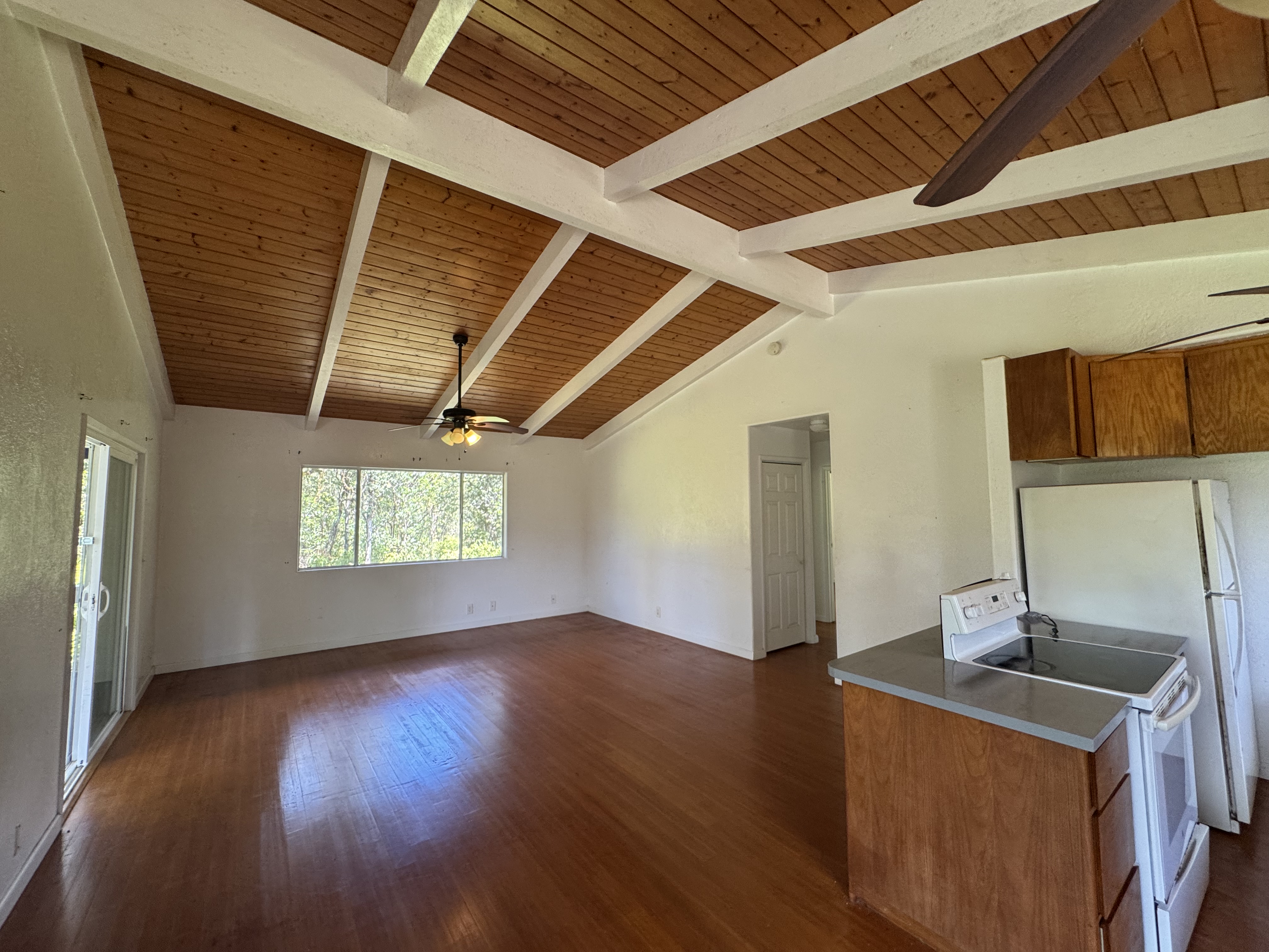 11-3132 Hibiscus Street Mountain View, HI 96771 - Photo 6 of 27 a kitchen with stainless steel appliances granite countertop a sink a stove a refrigerator and wooden floor