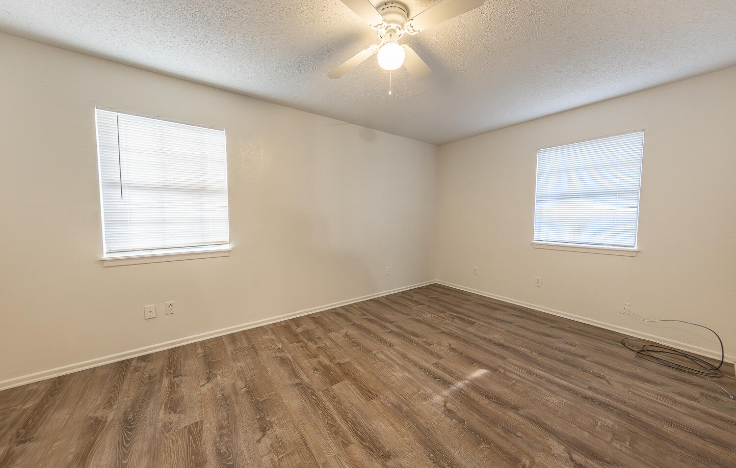 6305 35th Street Lubbock, TX 79407 - Photo 14 of 20 a view of an empty room with wooden floor and a window