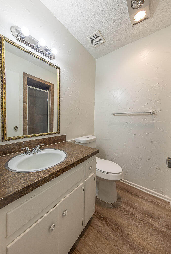 6305 35th Street Lubbock, TX 79407 - Photo 16 of 20 a bathroom with a granite countertop toilet sink and mirror