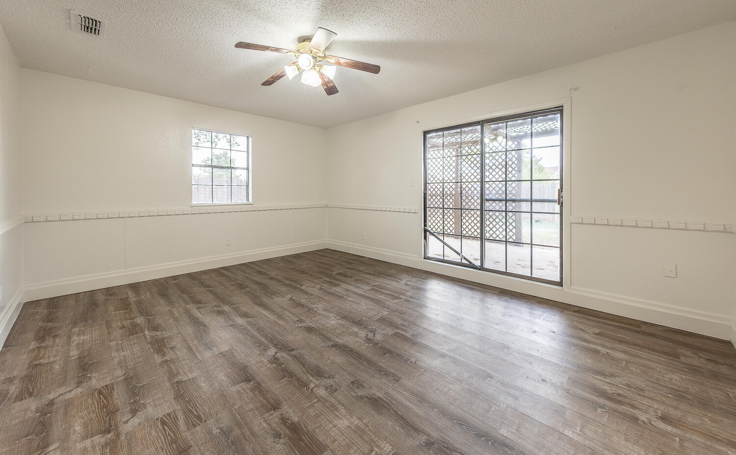 6305 35th Street Lubbock, TX 79407 - Photo 4 of 20 an empty room with wooden floor and windows