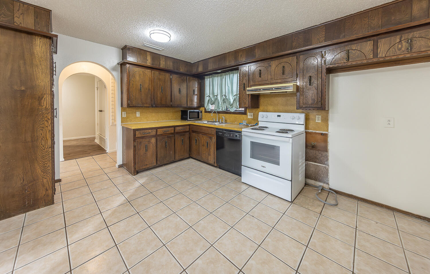 6305 35th Street Lubbock, TX 79407 - Photo 7 of 20 a kitchen with a stove a sink and a refrigerator