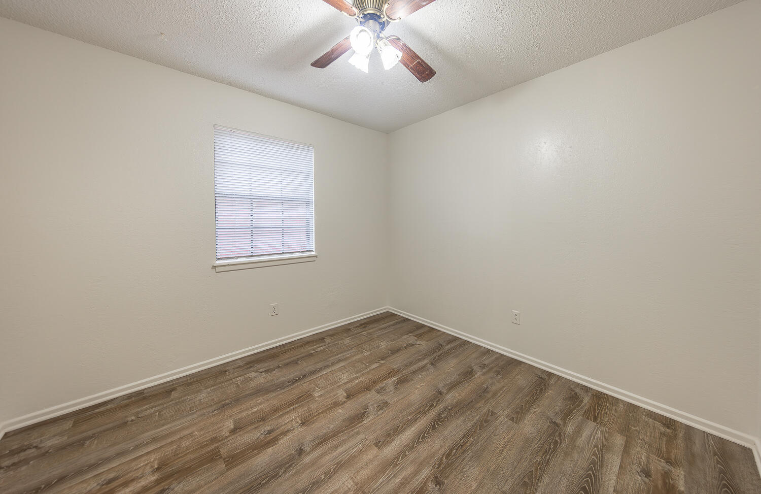 6305 35th Street Lubbock, TX 79407 - Photo 9 of 20 an empty room with a chandelier fan and windows