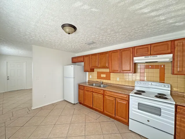 a kitchen with a stove sink and cabinets