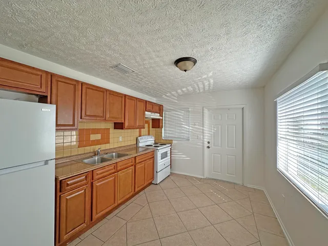 a kitchen with a refrigerator sink and cabinets