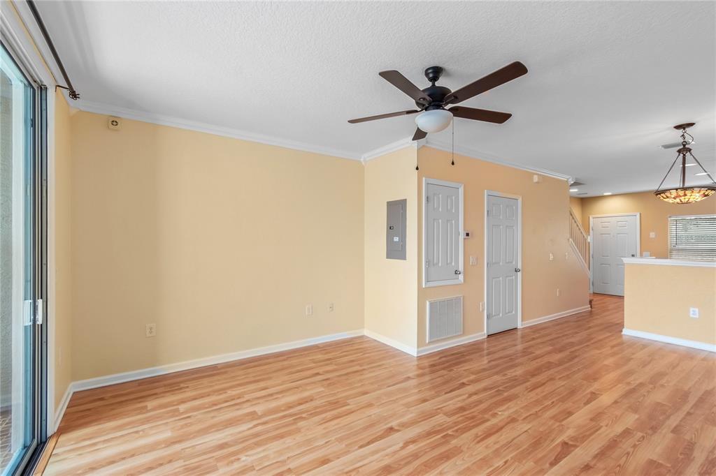 4814 Southwest 44th Circle Ocala, FL 34474 - Photo 15 of 40 a view of a livingroom with a ceiling fan & wooden floor