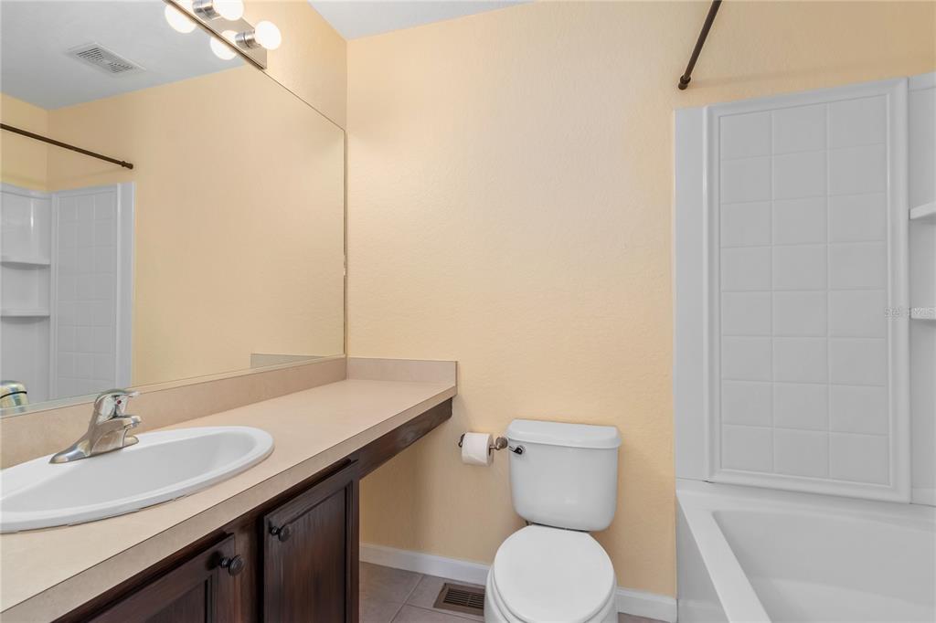 4814 Southwest 44th Circle Ocala, FL 34474 - Photo 20 of 40 a bathroom with a granite countertop toilet sink and mirror