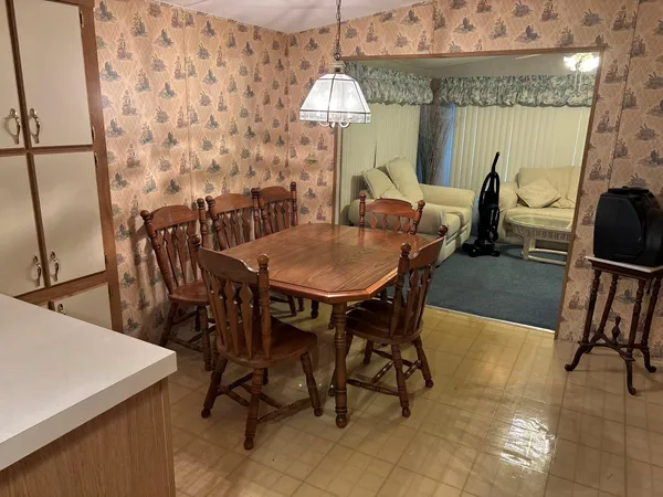 a dining room with furniture a chandelier and window