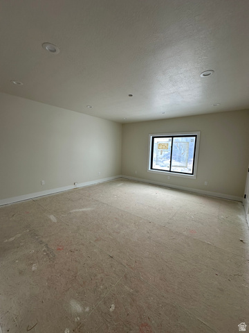 143 South Chamberlain Street, Unit 327 Mapleton, UT 84664 - Photo 10 of 12 Spare room featuring baseboards and a textured ceiling