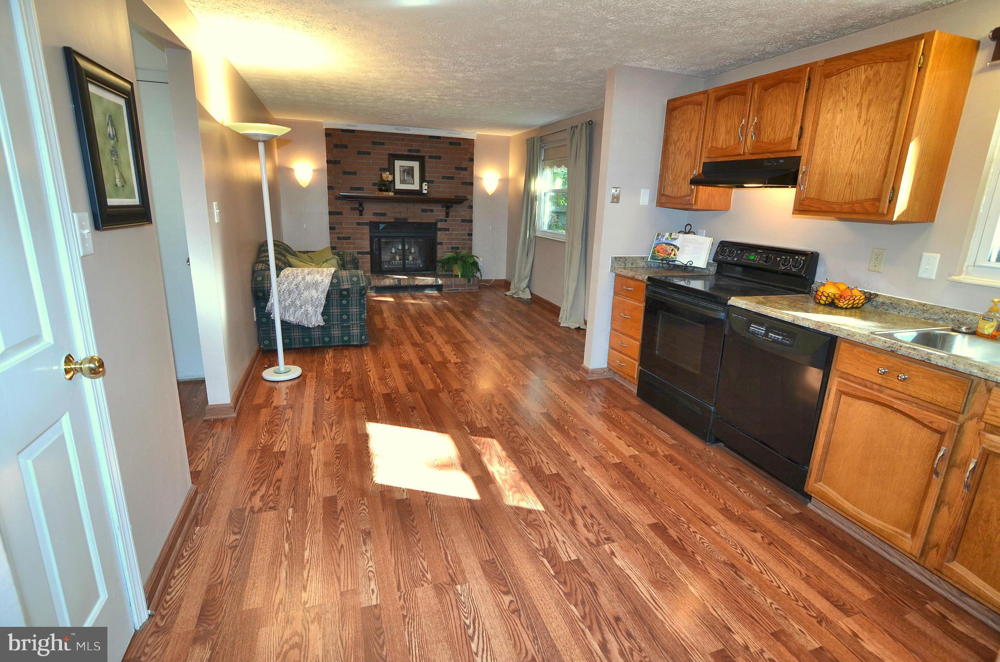 1503 Strider Court Hanover, MD 21076 - Photo 11 of 30 a kitchen with stainless steel appliances wooden floors wooden cabinets and sink