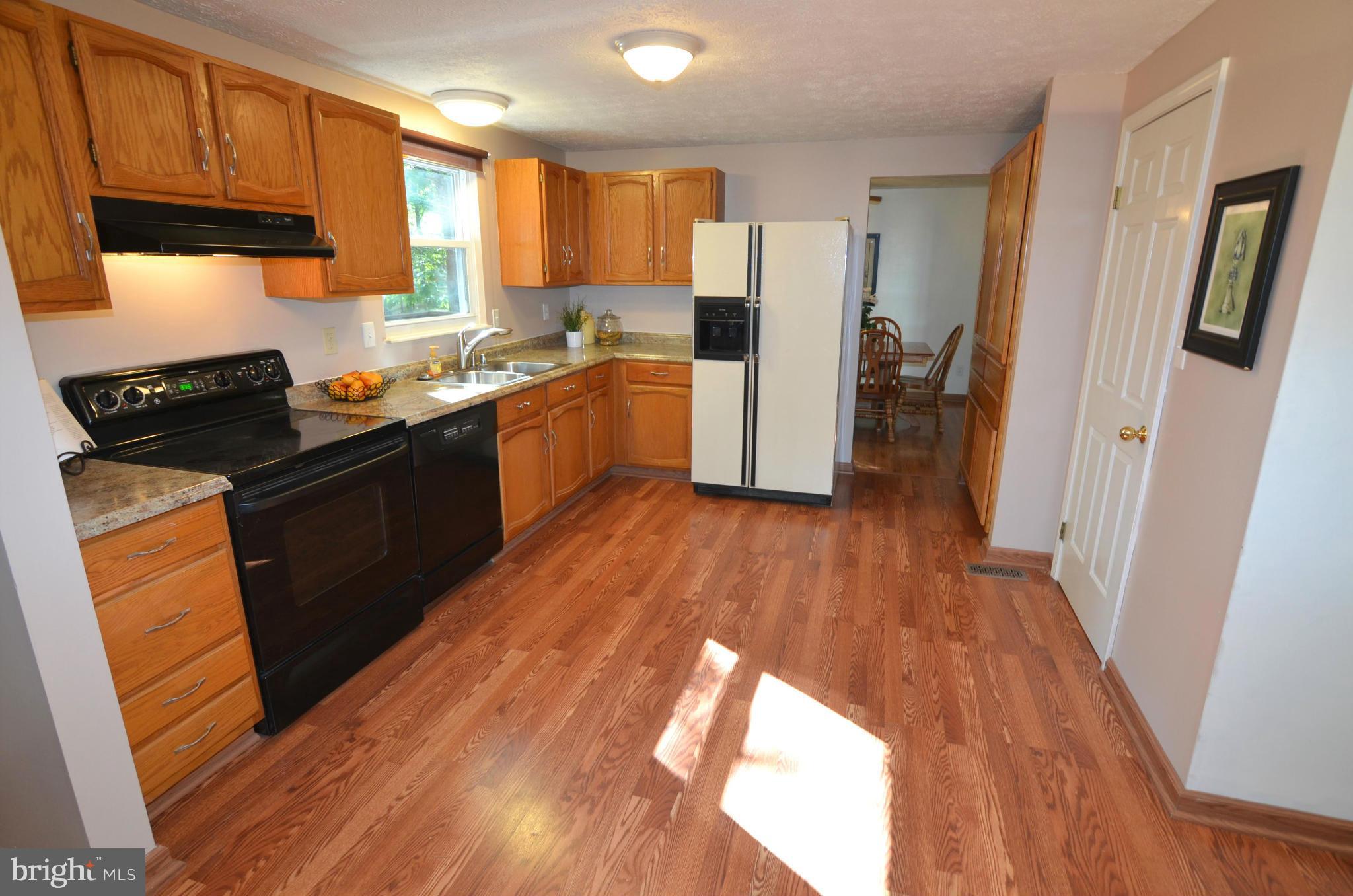 1503 Strider Court Hanover, MD 21076 - Photo 10 of 30 a kitchen with wooden floors and black appliances