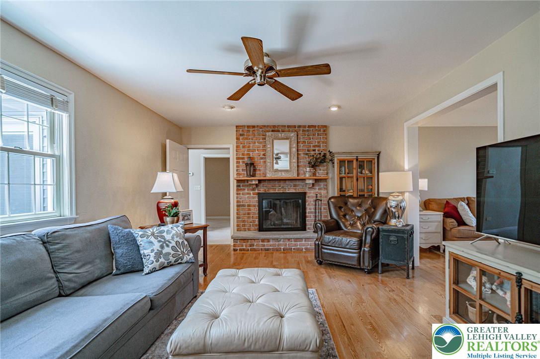 4542 Springfield Drive Coplay, PA 18037 - Photo 17 of 89 A comforting living area with a brick fireplace and warm wood flooring creates an inviting atmosphere.