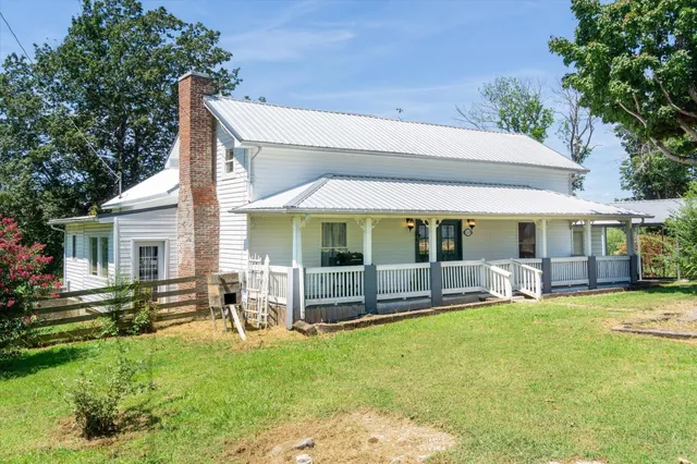 a view of a house with swimming pool and porch with furniture