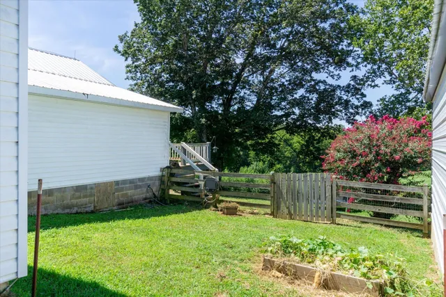 a view of backyard with wooden fence and a slide