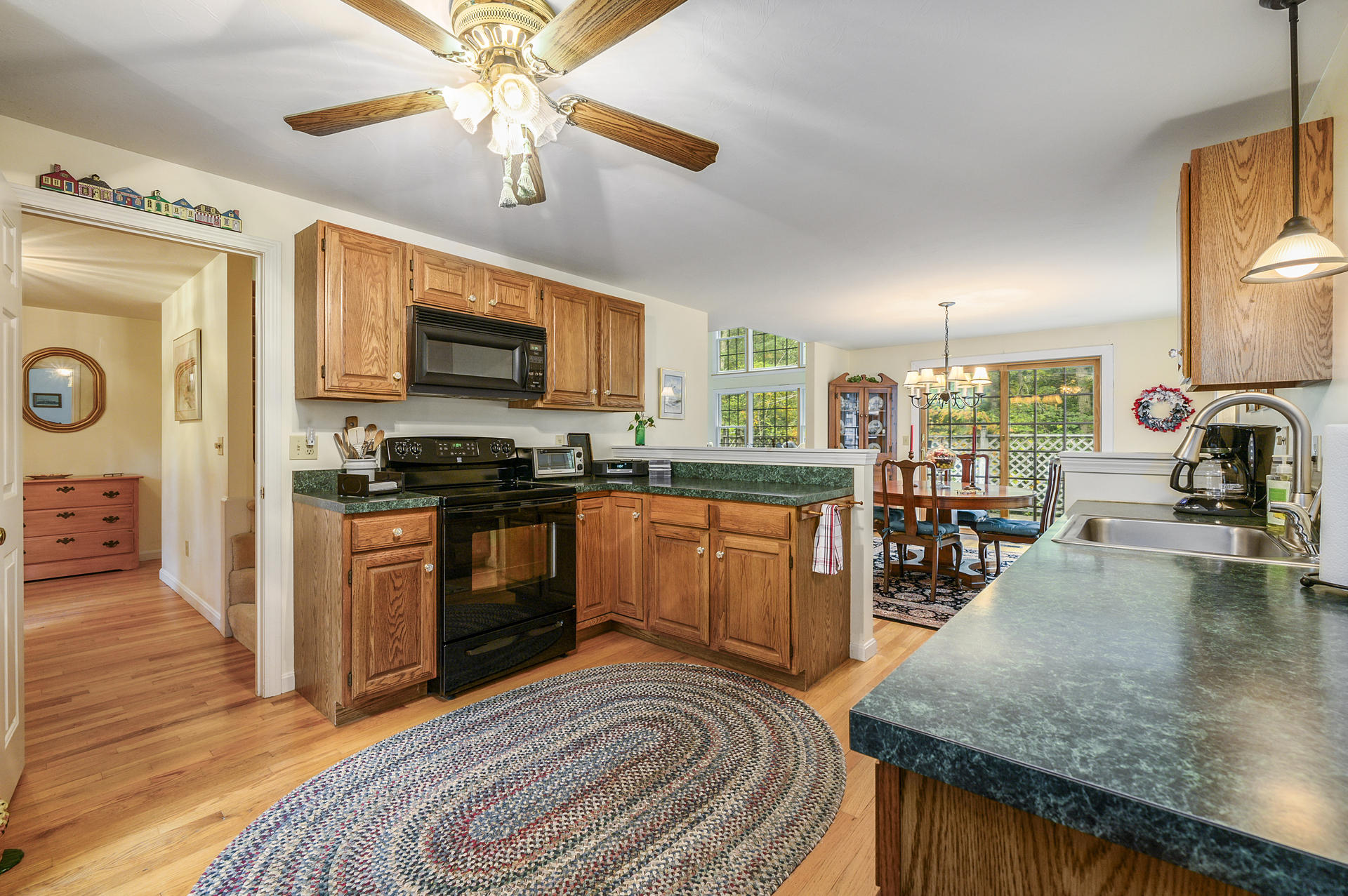 49 Hane Road Marstons Mills, MA 02648 - Photo 8 of 20 a kitchen with stainless steel appliances granite countertop a stove top oven a sink a dining table and chairs with wooden floor