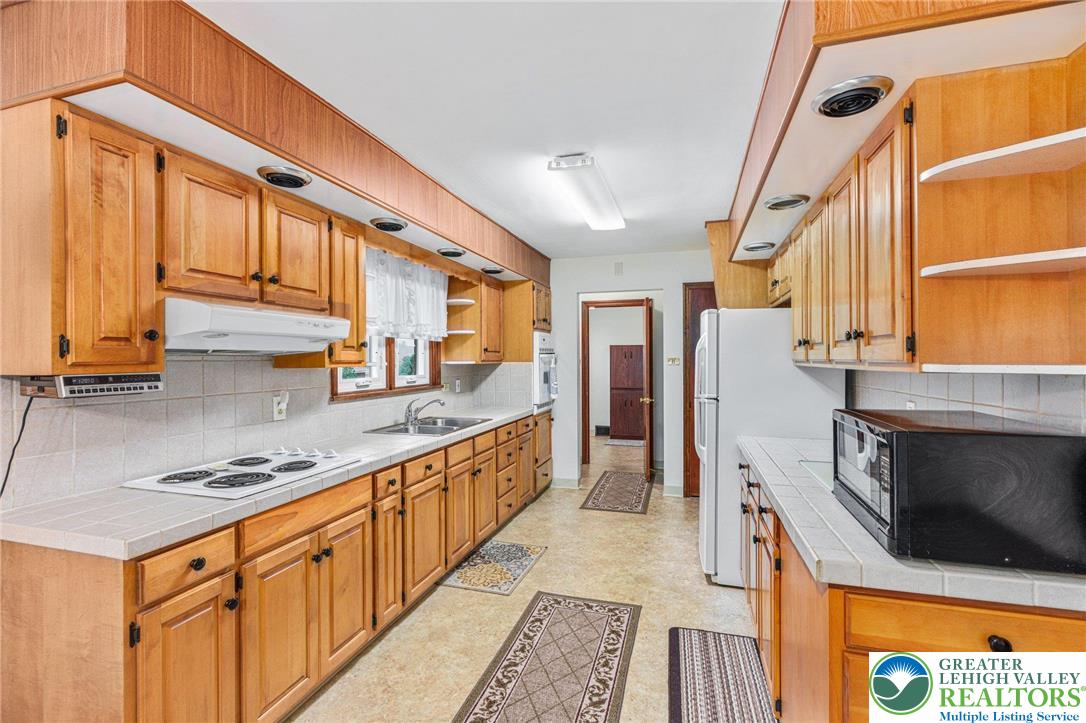 194 Gallagher Road Whitehall, PA 18052 - Photo 9 of 21 a kitchen with stainless steel appliances granite countertop a stove a sink and a microwave