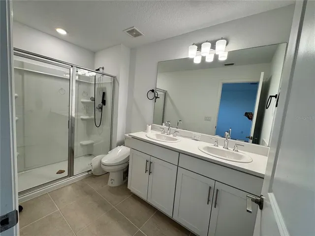 a bathroom with a double vanity sink mirror and toilet