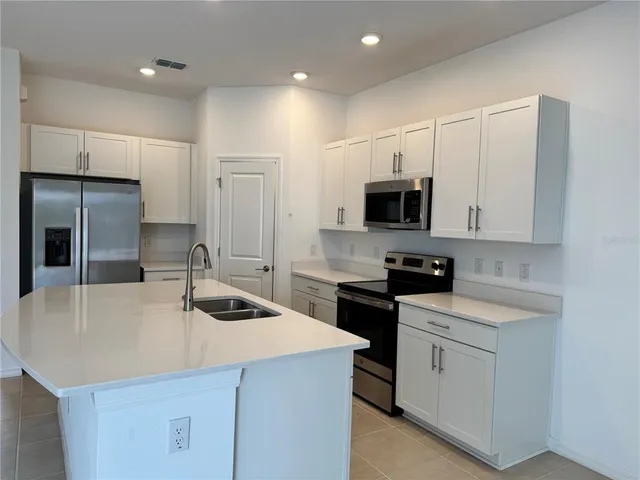 a kitchen that has a sink and a stove in it