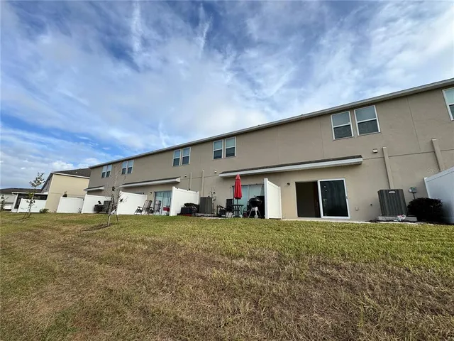 a view of a house with a big yard and large trees
