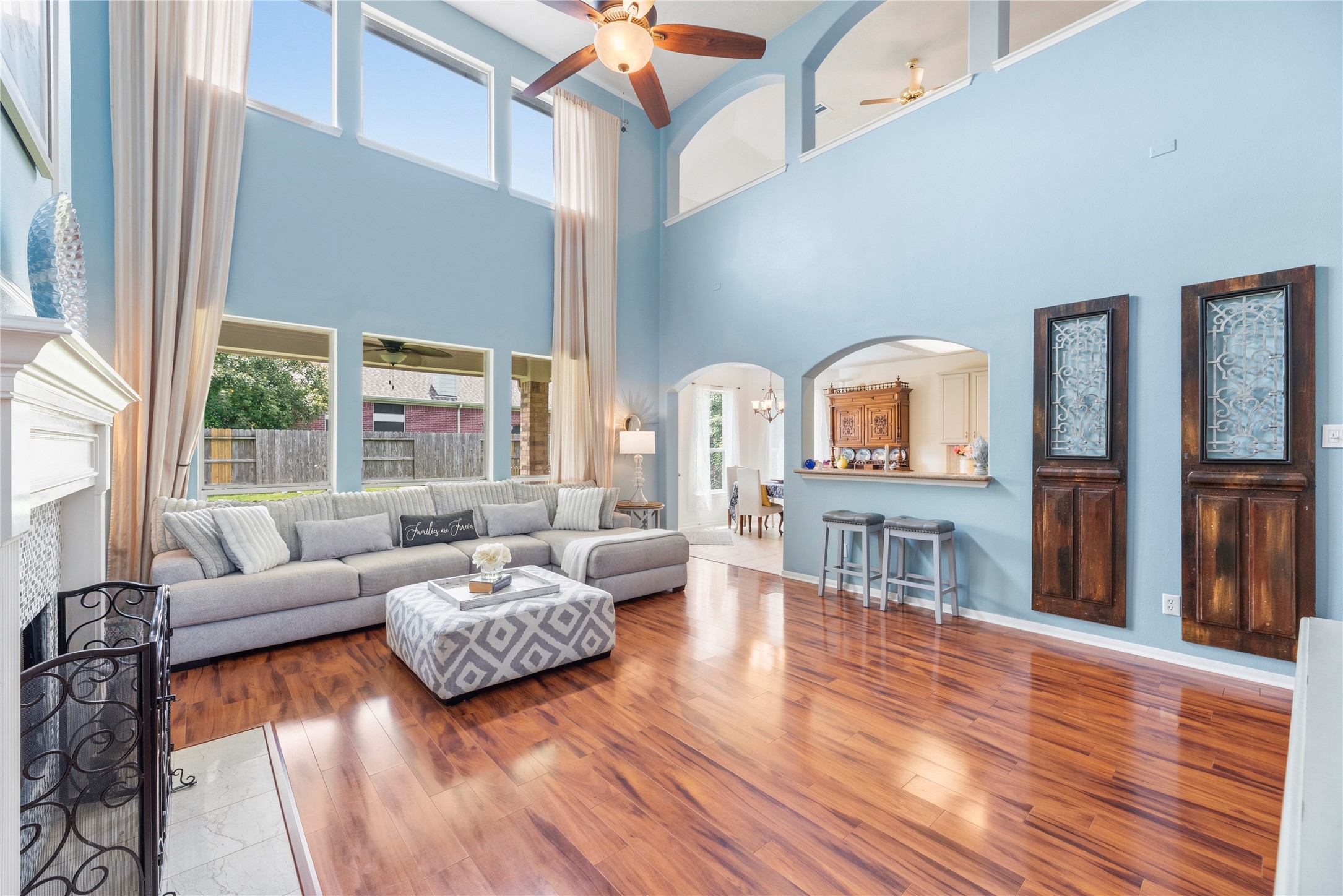 7930 Chateau Point Lane Houston, TX 77041 - Photo 9 of 34 This inviting living room features high ceilings, abundant natural light from large windows, and warm wood-look laminate flooring. It includes a cozy fireplace too!