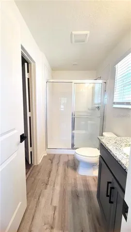 a bathroom with a granite countertop sink a large mirror and a shower