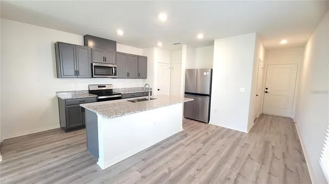 a kitchen with stainless steel appliances refrigerator stove microwave and cabinets