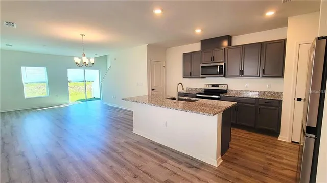 a kitchen with a sink a microwave a refrigerator and cabinets