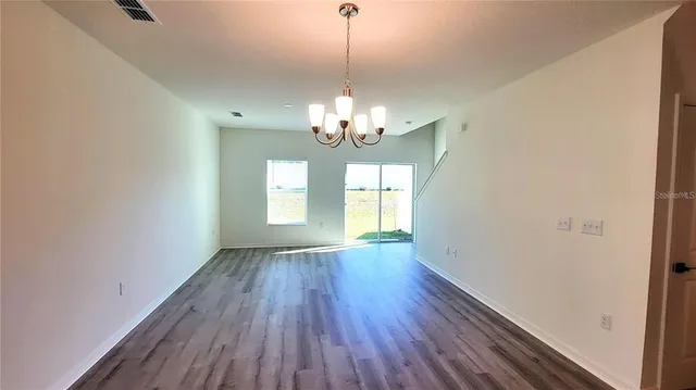 a view of a room with wooden floor and chandelier