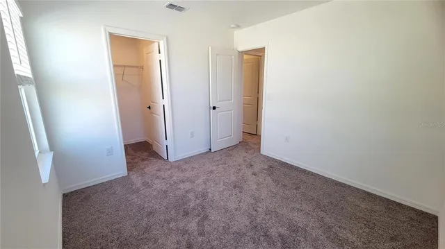 an empty room with closet and mirror