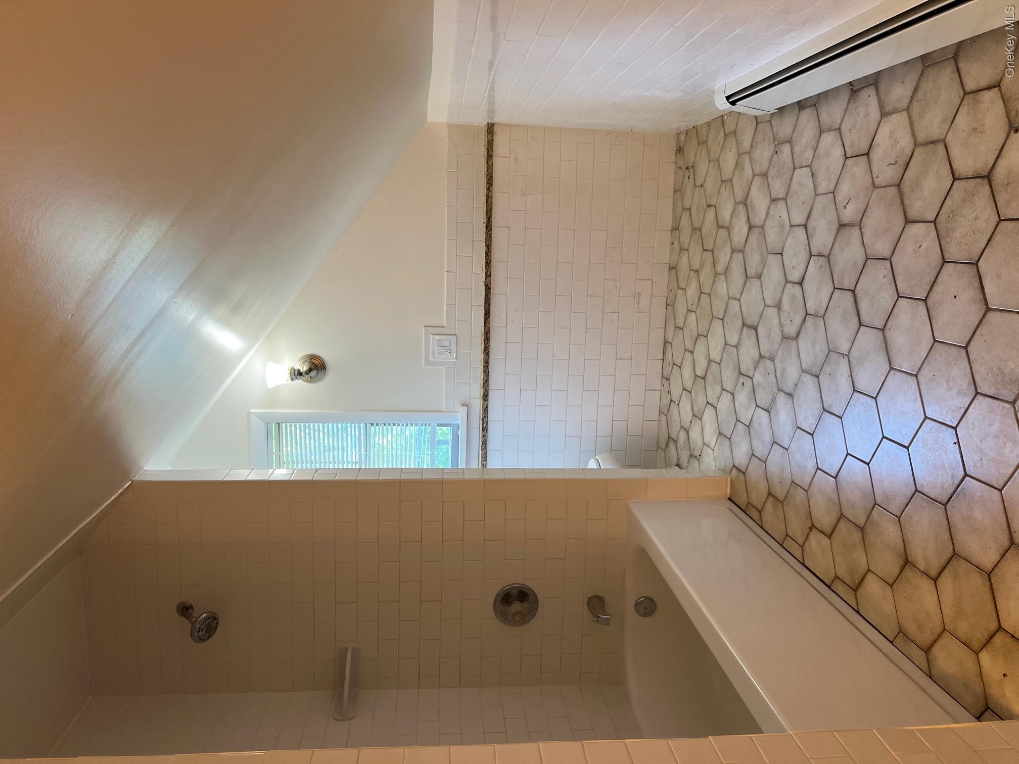 121 East Hook Cross Road Hopewell Junction, NY 12533 - Photo 11 of 16 Very large full bathroom with baseboard heating, tile walls, a wainscoted wall, washtub / shower combination, and lofted ceiling