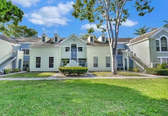 a view of a house with a big yard and large trees