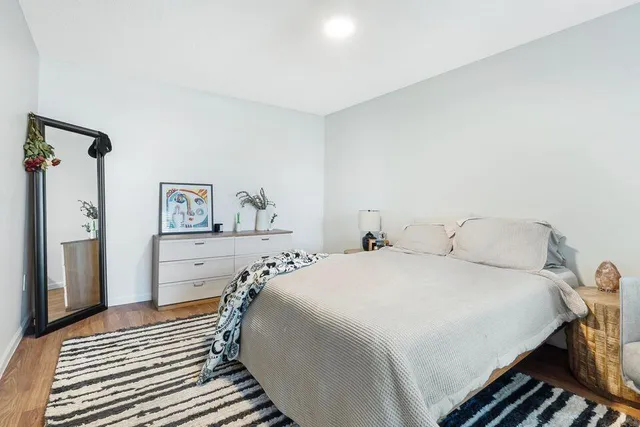 a bedroom with a bed and a painting on the wall