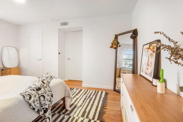 a bedroom with bed and wooden floor