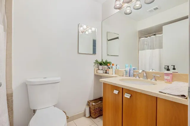 a bathroom with a granite countertop toilet sink and mirror