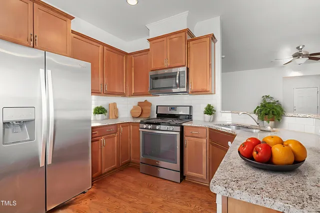 a kitchen with stainless steel appliances granite countertop a refrigerator stove and sink
