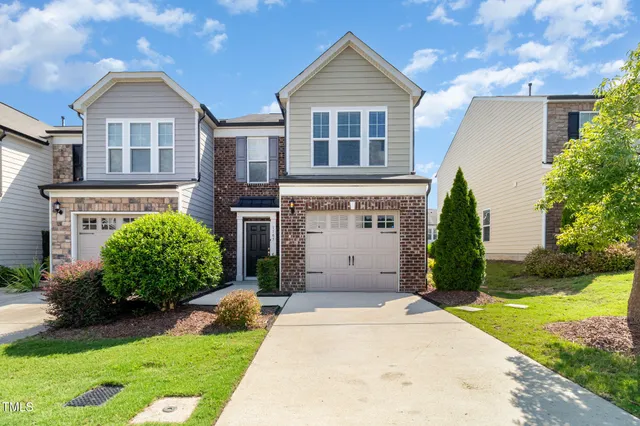 a front view of a house with a yard and potted plants