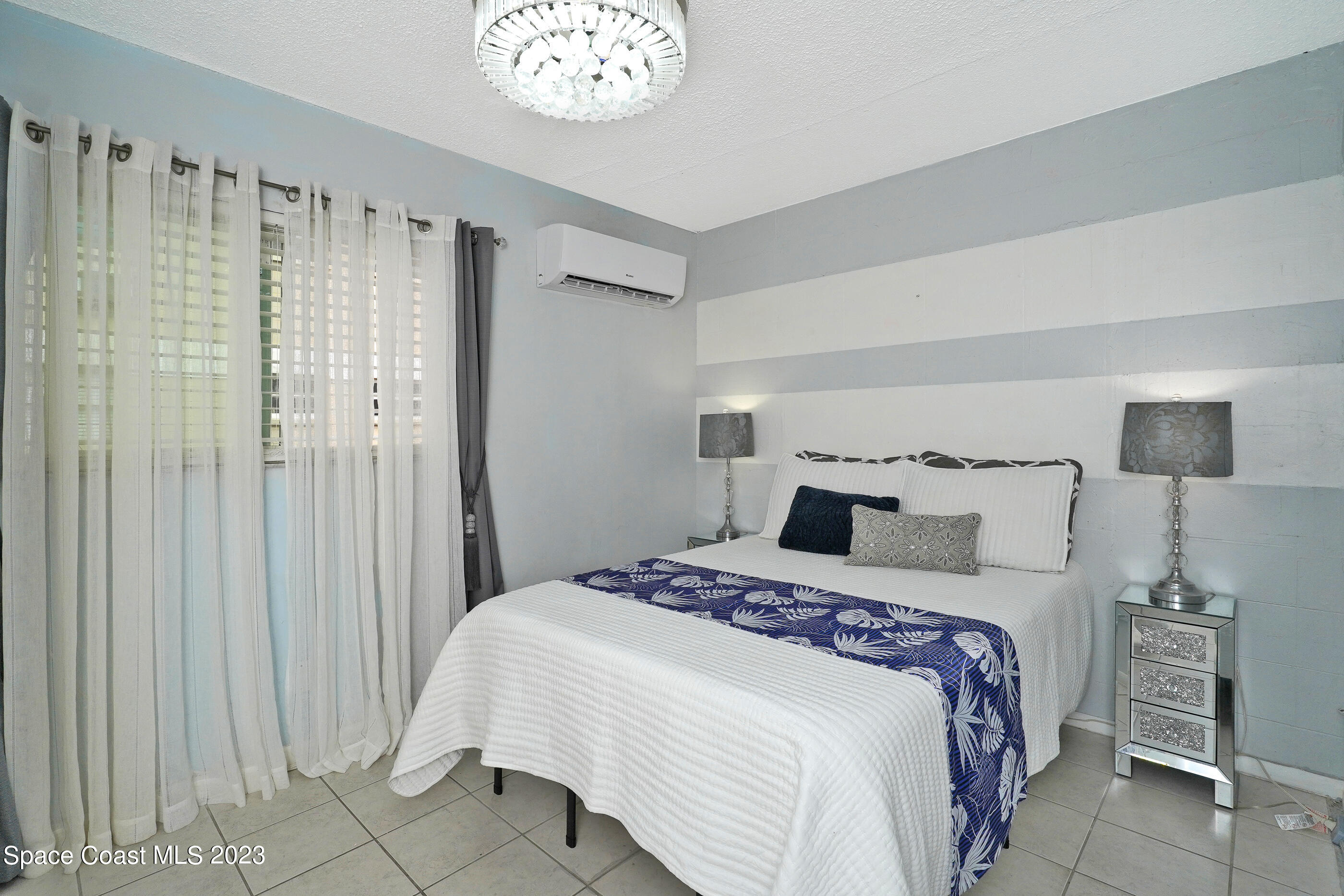 404 Tyler Avenue, Unit 14 Cape Canaveral, FL 32920 - Photo 11 of 29 a bedroom with a bed and a window
