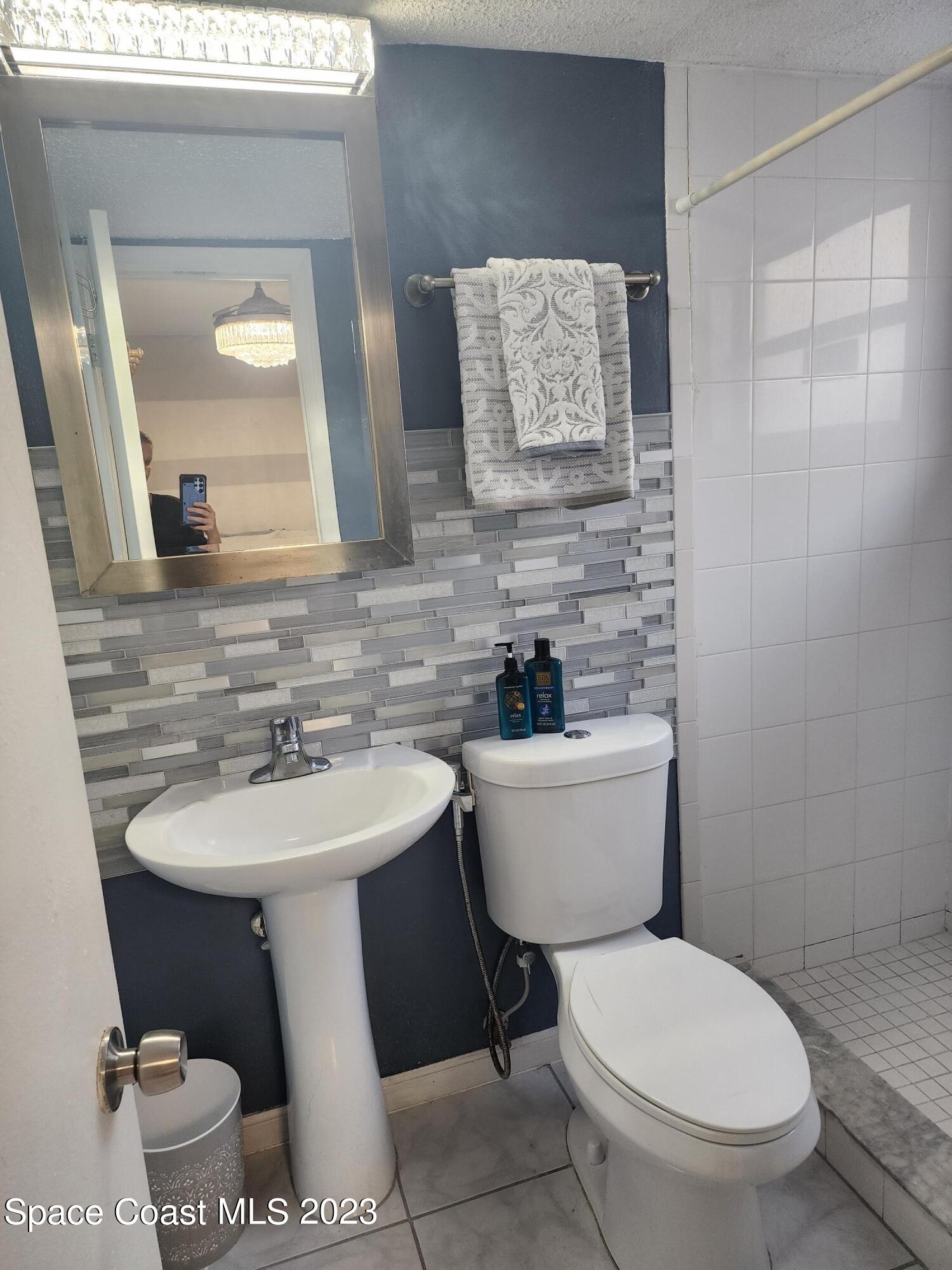 404 Tyler Avenue, Unit 14 Cape Canaveral, FL 32920 - Photo 13 of 29 a bathroom with a toilet sink and mirror