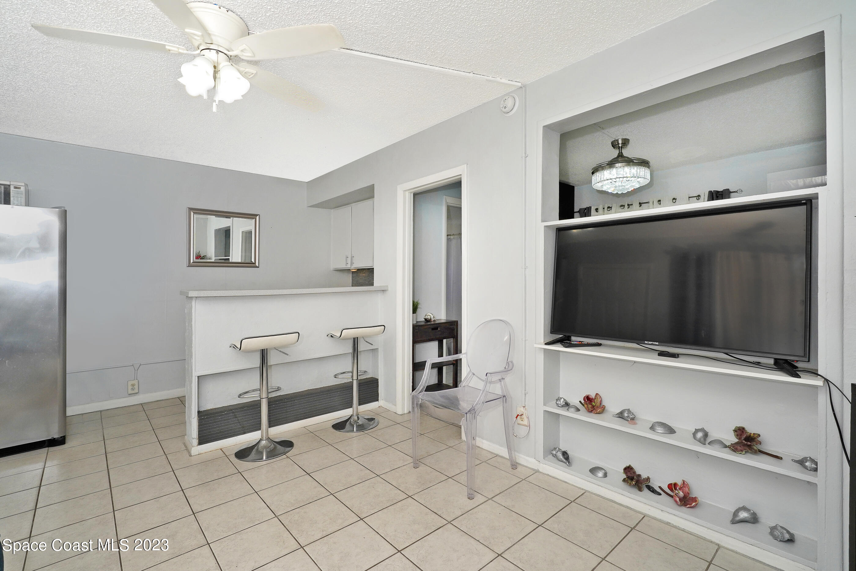 404 Tyler Avenue, Unit 14 Cape Canaveral, FL 32920 - Photo 5 of 29 a living room with furniture and flat screen tv