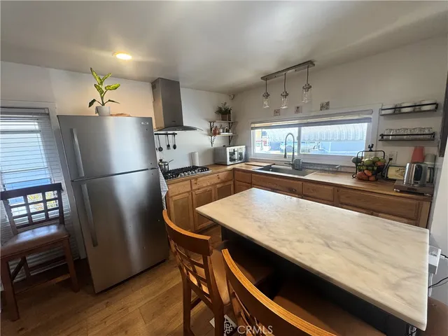 a kitchen with stainless steel appliances refrigerator and wooden floor