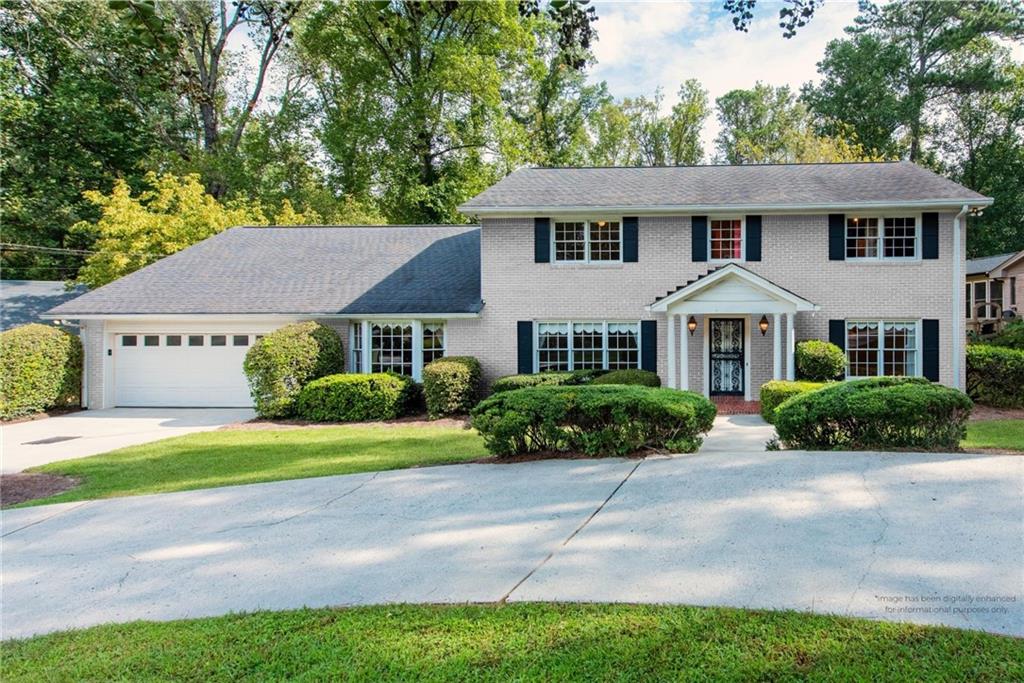 a front view of a residential houses with yard and green space
