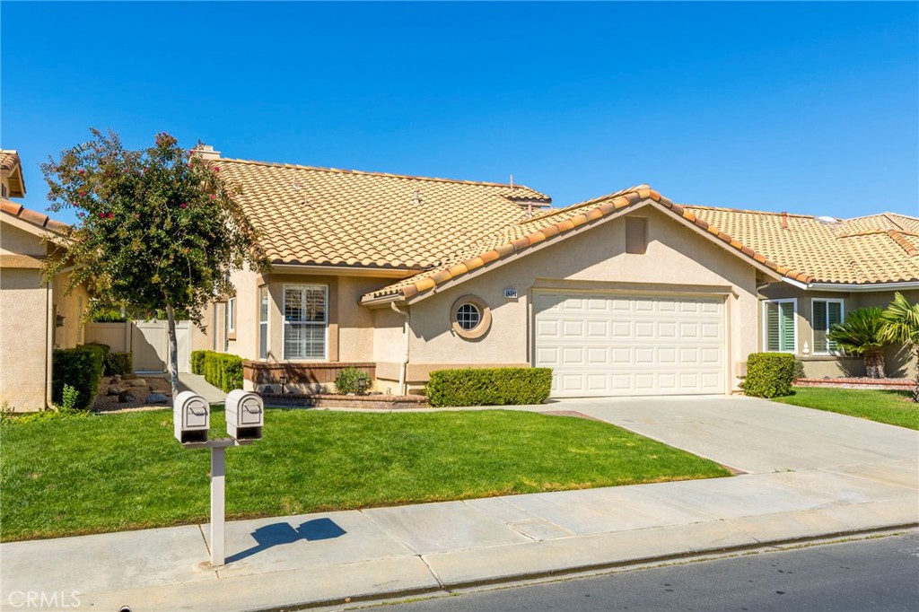 a front view of a house with a yard and trees
