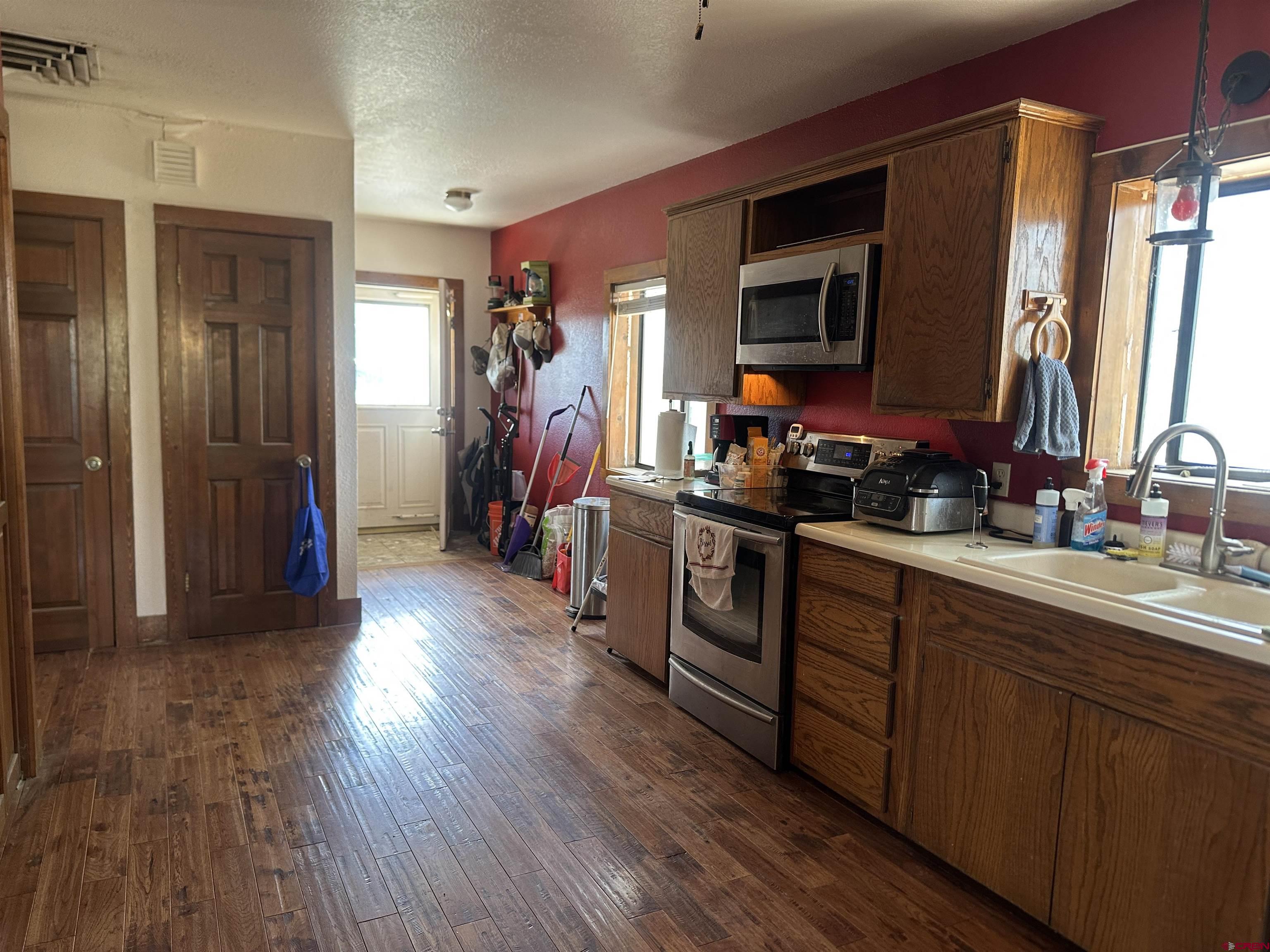 2468 1500th Road Delta, CO 81416 - Photo 13 of 45 a kitchen with stainless steel appliances granite countertop a refrigerator a sink dishwasher and wooden cabinets with wooden floor