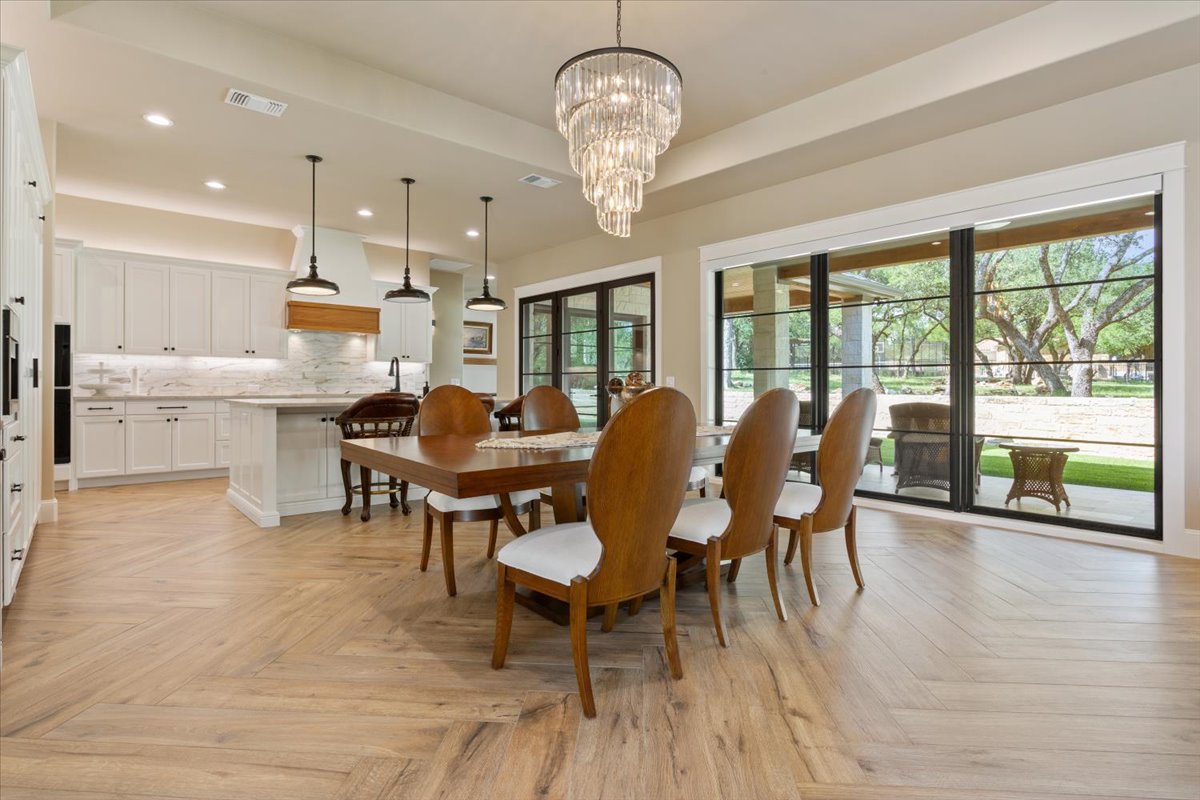 309 Highland Spring Lane Georgetown, TX 78633 - Photo 9 of 40 A view from a distance of the dining area with incredible chandelier and a continuation of the wall of windows/doors...