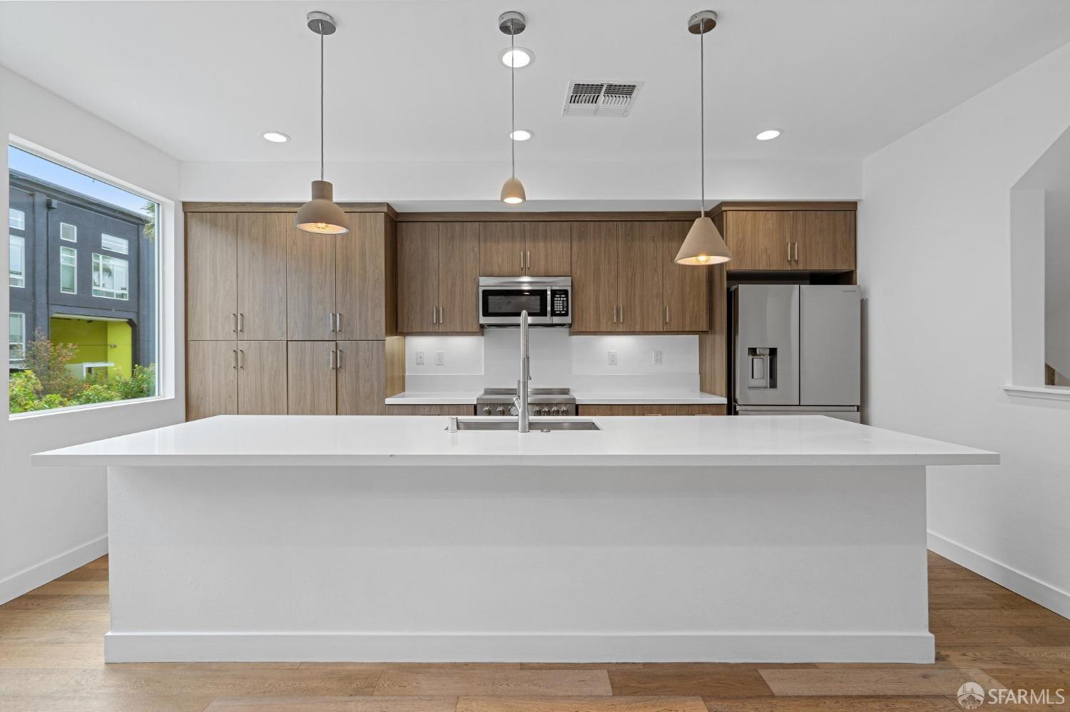 a large kitchen with kitchen island a sink stainless steel appliances and a counter top space