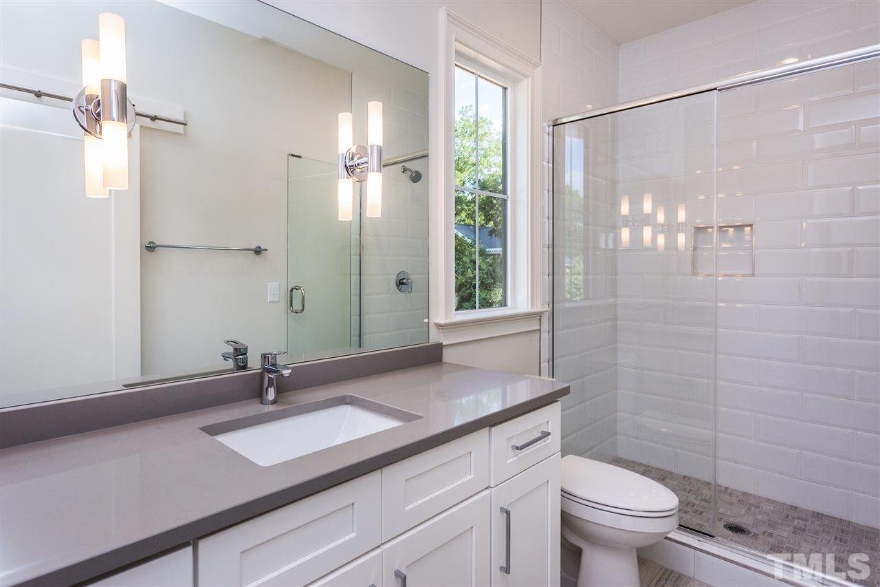3203.5 Clark Avenue Raleigh, NC 27607 - Photo 23 of 25 a bathroom with a granite countertop sink a toilet a mirror and shower