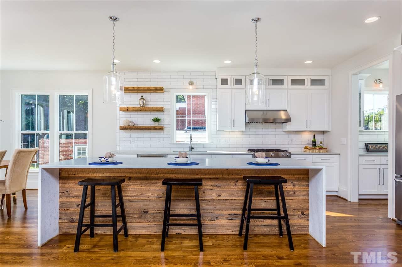 3203.5 Clark Avenue Raleigh, NC 27607 - Photo 7 of 25 a kitchen with stainless steel appliances granite countertop a stove a sink and white cabinets with wooden floor