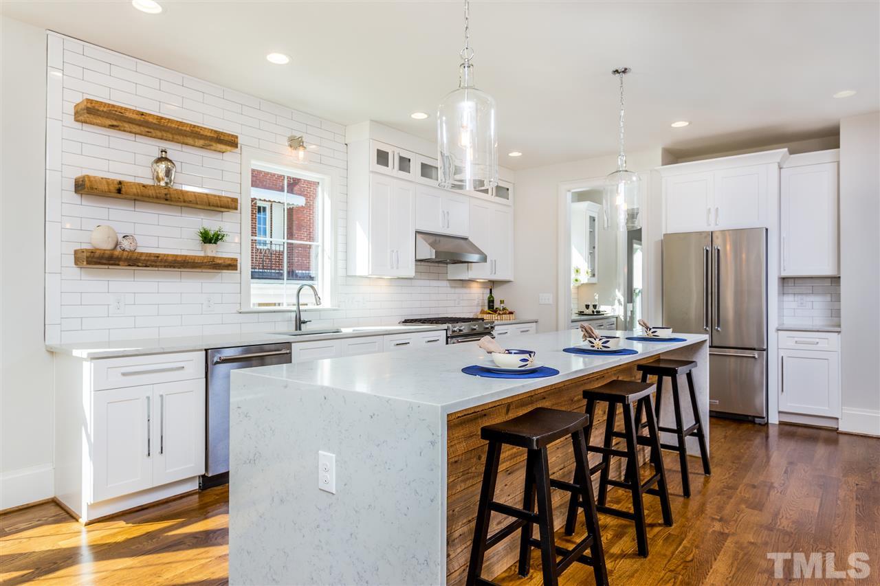 3203.5 Clark Avenue Raleigh, NC 27607 - Photo 9 of 25 a kitchen with stainless steel appliances granite countertop a sink a stove a refrigerator and island with wooden floor