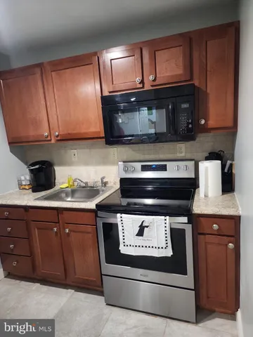a kitchen with stainless steel appliances granite countertop a stove a microwave and a sink