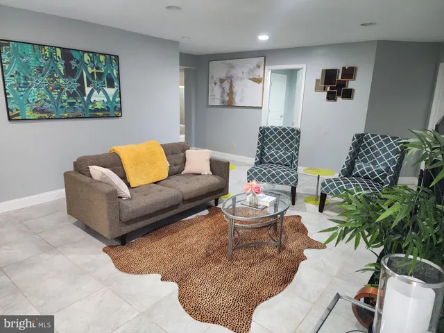 a living room with furniture and a potted plant