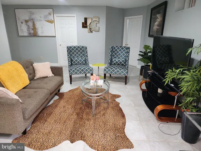 a living room with furniture a flat screen tv and a potted plant